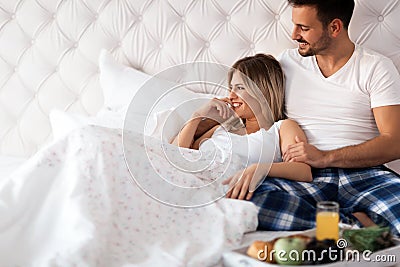 Romantic happy couple having breakfast in bed Stock Photo