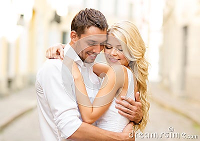 Romantic happy couple hugging in the street Stock Photo