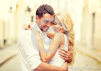 Romantic happy couple hugging in the street Stock Photo