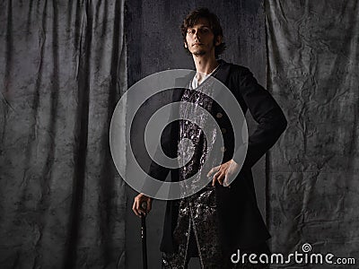 Romantic hero, a young man in an old suit with a cane, a doublet with a vest, Stock Photo