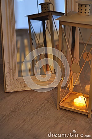 Romantic lantern reflection. Decorative mirror frame. Relaxing candlelight flame. Peaceful home interior Stock Photo