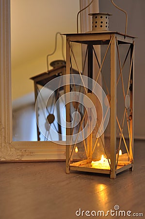 Romantic lantern reflection. Decorative mirror frame. Relaxing candlelight flame. Peaceful home interior Stock Photo