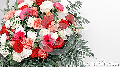 Romantic large bouquet flowers on light background. Red and ivory rose, coral carnation, pink gerbera daisy flowers and fern Stock Photo