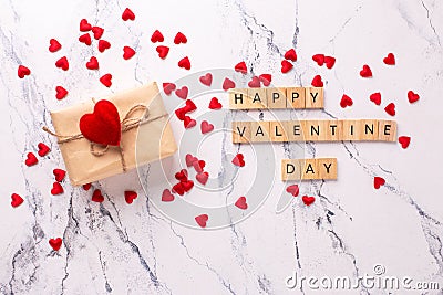 Romantic layout. Box with present with hearts, wooden latters on white marble background. Stock Photo
