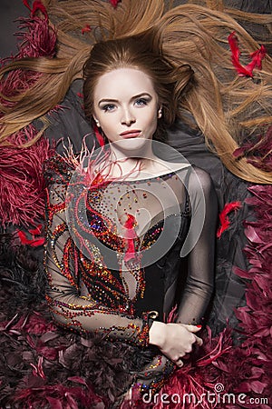 Romantic look. Interesting ginger model surrounded with feathers Stock Photo