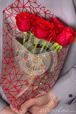 A man holding a bouquet of red roses Stock Photo