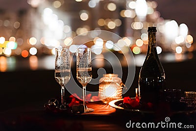 Romantic luxury evening with champagne setting with two glasses, rose petails and candles Stock Photo