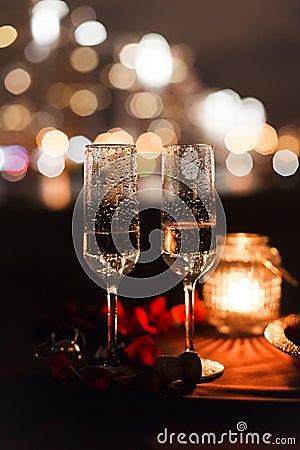 Romantic luxury evening with champagne setting with two glasses, rose petails and candles Stock Photo