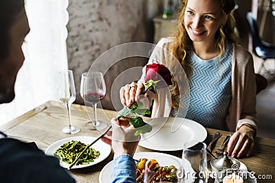 Romantic Man Giving a Rose to Woman on a Date Stock Photo