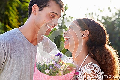 Romantic Man Giving Woman Bunch Of Flowers Stock Photo