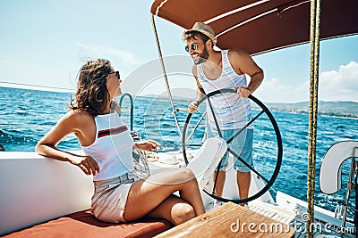 Romantic man and woman on a yacht enjoy bright sunny day on vacation Stock Photo