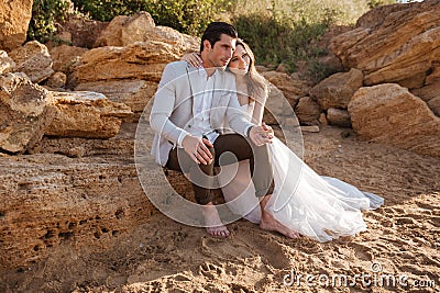 Romantic married couple sitting on the beach Stock Photo