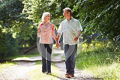 Romantic Middle Aged Couple Walking Along Countryside Path Stock Photo