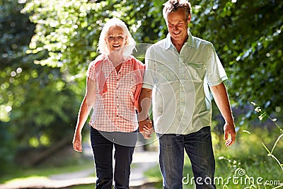 Romantic Middle Aged Couple Walking Along Countryside Path Stock Photo