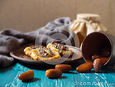 Romantic morning still life, in a rustic style with cookies, a glass jar of honey and scattered dates on a turquoise wooden Stock Photo