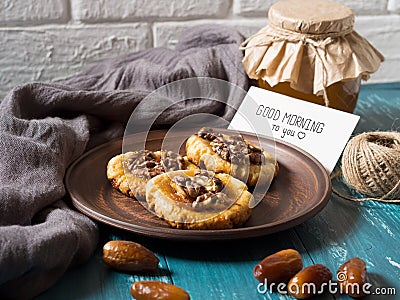 Romantic morning still life in a rustic style with cookies, honey and dates on a turquoise wooden background, with a white card Stock Photo