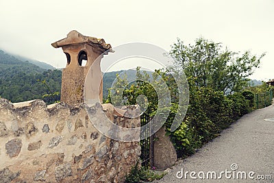 Romantic narrow street with stone fence and chimney in mediterranean village in island Majorca Stock Photo