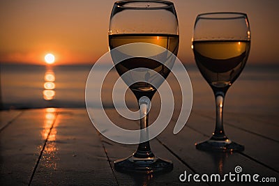 Romantic outdoor activity. Two glasses with white wine in an outdoor restaurant with sunset sea view, relaxation concept for two Stock Photo