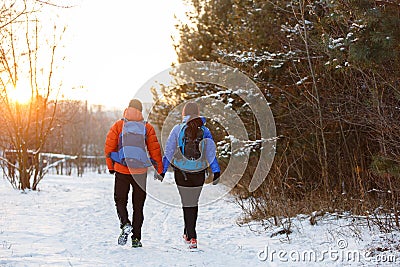 Romantic picture from back of man and woman with backpacks in winter Stock Photo