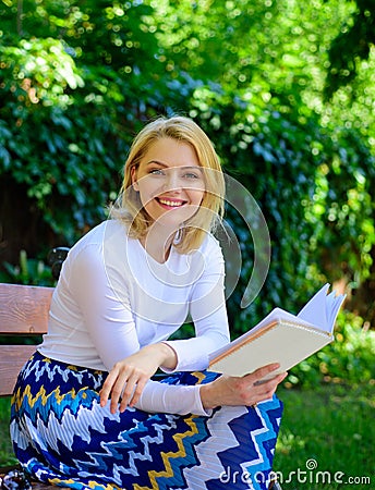 Romantic poem. Enjoy rhyme. Woman happy smiling blonde take break relaxing in garden reading poetry. Girl sit bench Stock Photo