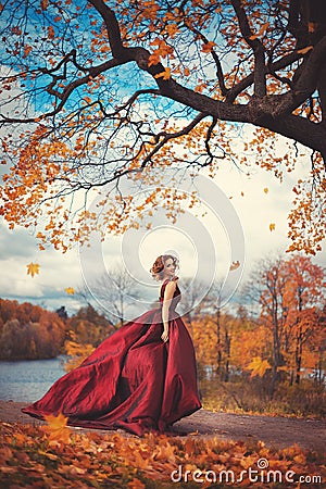 Romantic portrait of a young girl in a long red dress Stock Photo