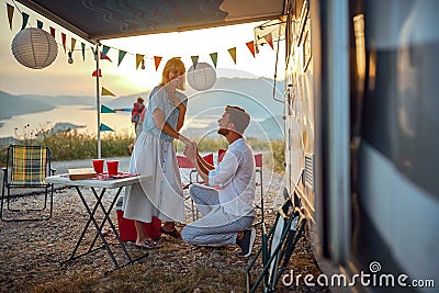 romantic proposal in nature during the holiday in front of the camper Stock Photo