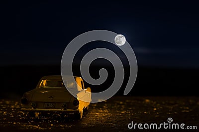Romantic scene of old vintage car with couple inside and Moon on sky at night. Silhouette love and car on Full Moon Background. Se Stock Photo