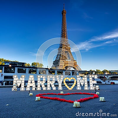 The romantic scenery of a marriage proposal with the inscription marry me in front of the Eiffel Tower in Paris, France Stock Photo