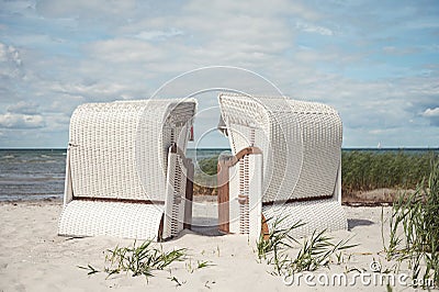 Romantic sea scene at white beach with beach chair at summer sunny day in north Germany Stock Photo