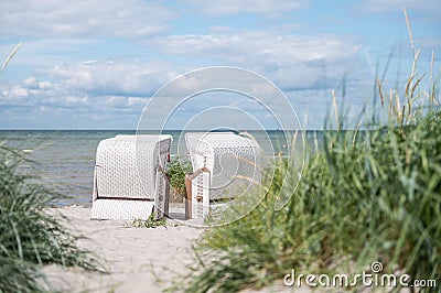 Romantic sea scene at white beach with beach chair at summer sunny day in north Germany Stock Photo