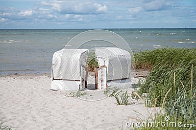 Romantic sea scene at white beach with beach chair at summer sunny day in north Germany Stock Photo