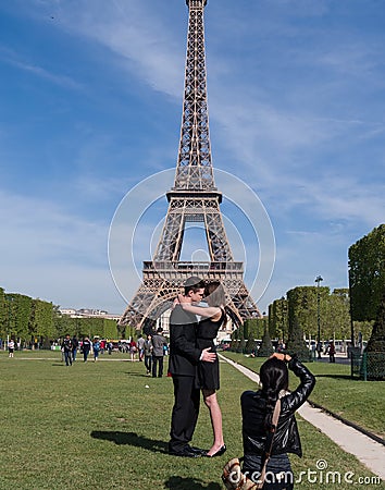 A couple takes a photo in front of the Eiffel Tower in Paris, France Editorial Stock Photo