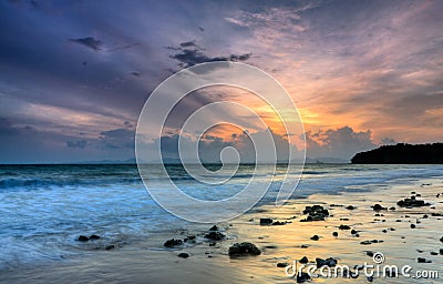 Romantic sunset at a rocky beach Stock Photo