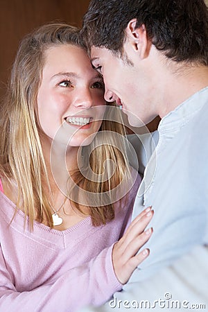 Romantic Teenage Couple Sitting On Sofa At Home Stock Photo