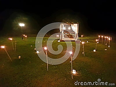 Romantic terrace with torches in a field Stock Photo