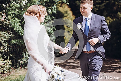 Romantic wedding moment, couple of newlyweds smiling portrait, bride and groom hug while on a walk in the park Stock Photo