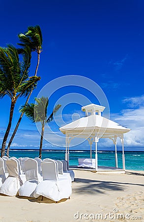 Romantic white gazebo in the exotic Caribbean gardens with palm trees. Stock Photo