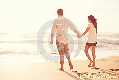 Romantic Young Couple on the Beach at Sunset Stock Photo