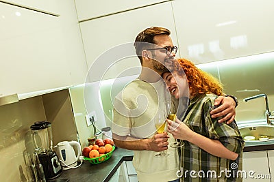 Young couple cooking together in the kitchen,having a great time together, drink wine Stock Photo