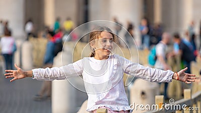 Rome, Italy - 29.10.2019: happy beautiful girl with outstretched arms in the Vatican Square Editorial Stock Photo