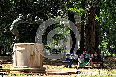 Fontana della famiglia dei Satiri in Villa Borghese garden with three women reading on the bench nearby Editorial Stock Photo