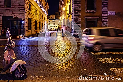 Vespa bike and passing cars in central Rome. Night scene Editorial Stock Photo