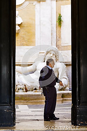 Security guard officer in front of colossal statue of Neptune in Palazzo Nuovo Editorial Stock Photo