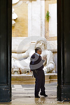 Security guard officer in front of colossal statue of Marforio in Palazzo Nuovo Editorial Stock Photo