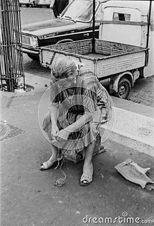 Rome, Italy, 1970 - An old lady thoughtfully unties the knots of a string Editorial Stock Photo