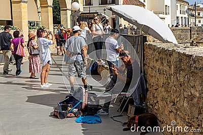 Street musician near Puente Nuevo Bridge at sunset in Ronda, Spain on October 23, 2022 Editorial Stock Photo