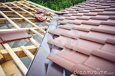 Roof building at new house construction. Brown roof tiles covering estate Stock Photo
