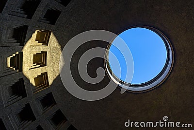 Roof of the dome of the pantheon in Rome seen from the inside with circular hole in the blue sky and light projected on top. Editorial Stock Photo