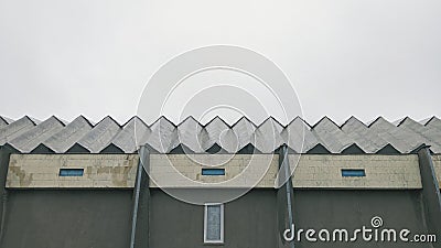 roof and facade of the building against the gray sky Stock Photo