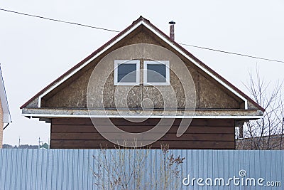 Roof of a little house with a pipe and two windows Stock Photo